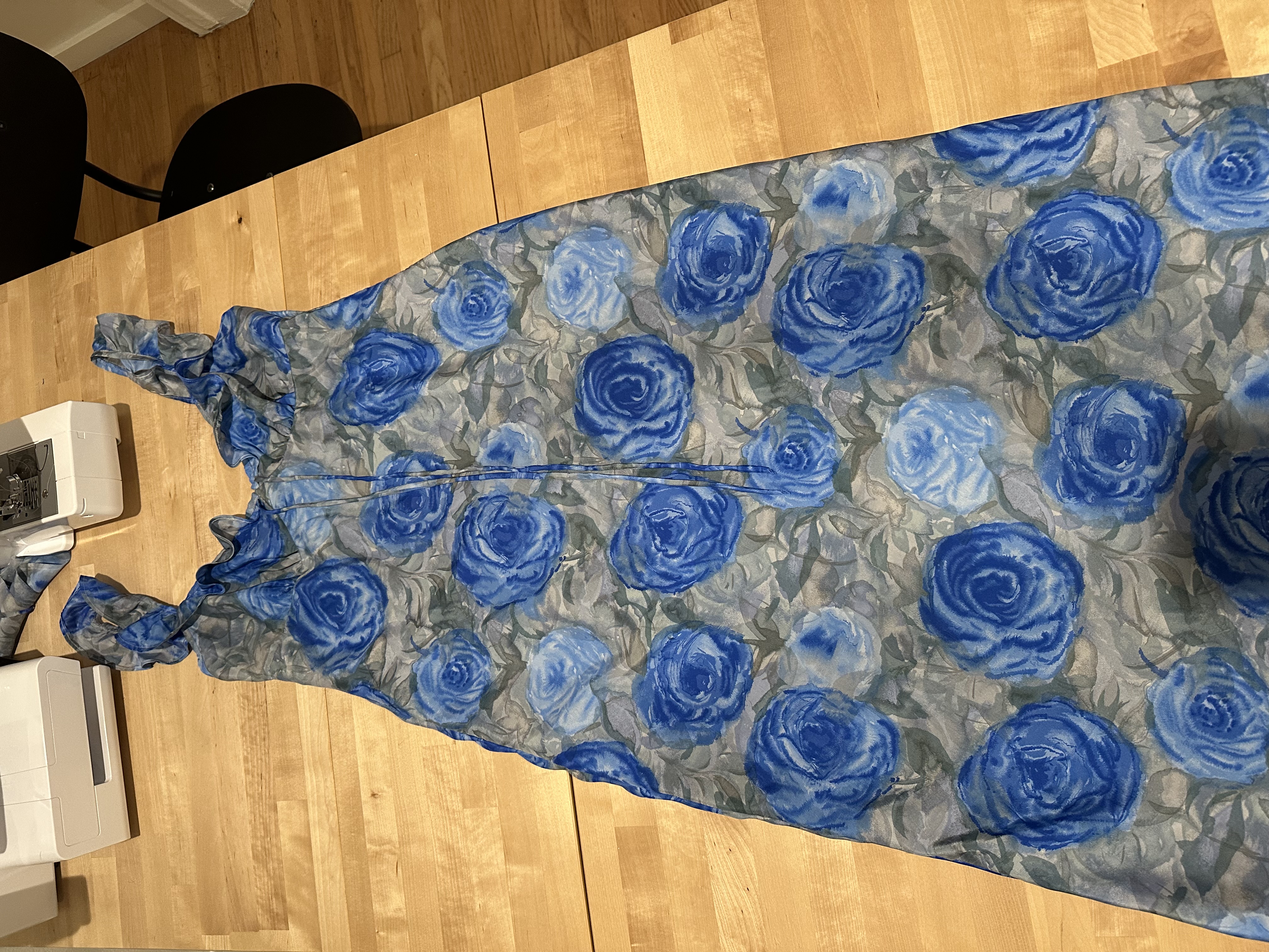 The finished Nelly Dress laid out on the cutting table next to the sewing machine